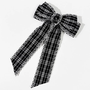 Close-up of black and white plaid tweed bow hair clip with elegant long ribbons