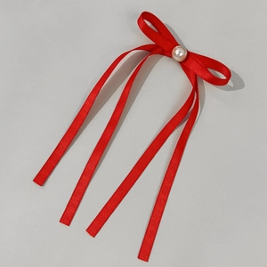 Dettaglio fiocco in seta rossa con perla centrale e lunghi nastri eleganti pendenti