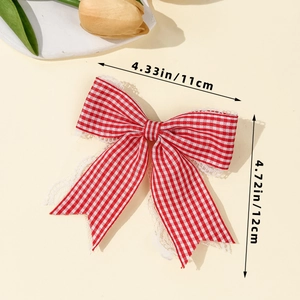 Dettaglio fiocco per capelli a quadri rossi con pizzo e dimensioni indicate 11x12 cm