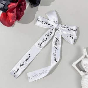 Détail du nœud en satin blanc avec lettrage noir Just for you et motifs de petits cœurs
