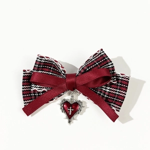 Barrette à cheveux avec nœud à carreaux rouge et pendentif cœur argenté avec une croix
