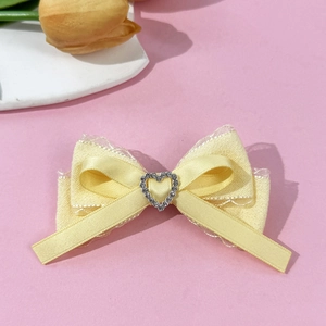 Sweet ballet style light yellow silk bow hair clip with rhinestone heart on pink backdrop