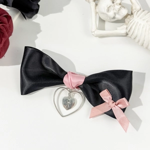 Gothic black satin bow hair clip featuring a pink ribbon and cross heart pendant detail