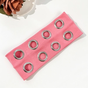 Dettaglio della fascia in maglia a coste rosa con otto occhielli metallici per look punk
