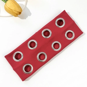 Détail d'un bandeau punk en maille côtelée rouge avec de grands œillets métalliques