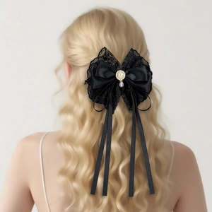 Elegant black lace bow hair clip with pearls and long ribbons on blonde wavy hair