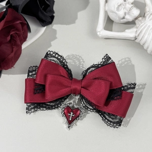 Detailed shot of dark gothic bow hair clip with red heart pendant and black lace edge