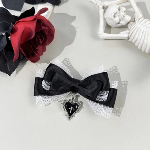 Detail shot of black lace bow hair clip with silver cross heart pendant and gothic roses