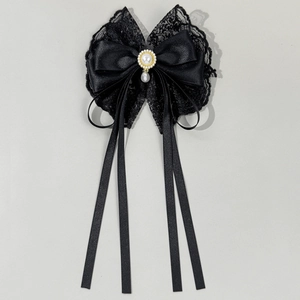 Detail of black lace bow hair clip with faux pearl pendant and long ribbons