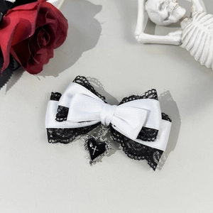 Gothic lace bow hair clip featuring a black heart and silver cross detail close-up