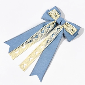 Détail du nœud en jean bleu clair avec rubans en dentelle à motifs de cœurs évidés