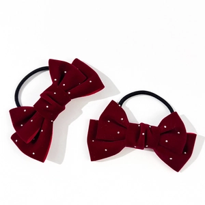 Pair of deep wine red velvet bow hair ties with sparkling white rhinestones on white base