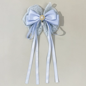 Detail of light blue lace bow hairpin with satin ribbons and dangling pearl pendant