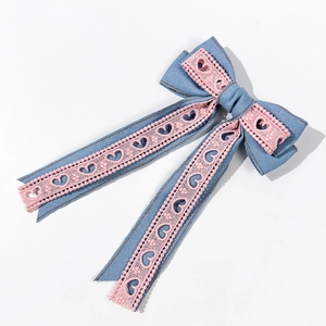 Détail du nœud papillon en denim bleu clair avec dentelle cœur rose et longs rubans