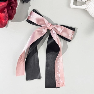 Close-up of the double-layer bow hair clip with Just For You text and smooth silk texture