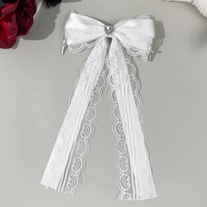 Détail du nœud gothique blanc avec bijou en cœur et pendentifs croix en argent poli