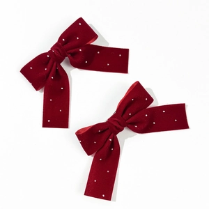 Elegant pair of red velvet bow hair clips with pearls and rhinestones on white background