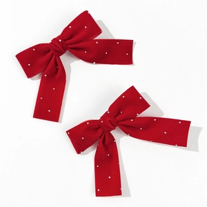 Pair of red velvet bow hair clips with pearls on a clean white background
