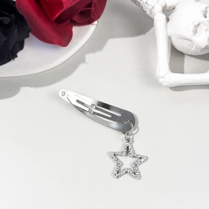 Détail de la barrette argentée avec un pendentif étoile étincelant au style esthétique y2k