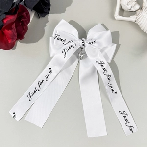 Fermaglio per capelli con fiocco in raso bianco e ciondolo a cuore con strass