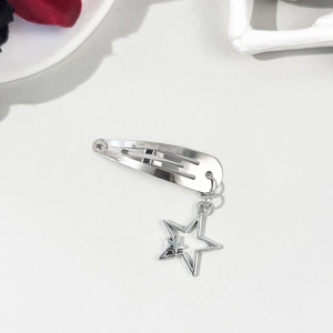 Détail de la pince à cheveux argentée avec pendentif étoile et design double pentagramme