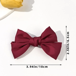 Detail view of the wine red satin bow hair clip with exact size markings of 10cm x 6.5cm