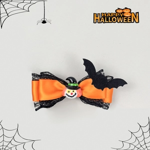 Détail de la barrette Halloween avec dentelle noire, satin orange et décorations de chauve-souris