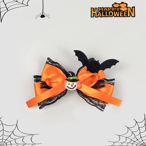 Détail d'un nœud d'Halloween en satin orange avec dentelle noire et charm de clown