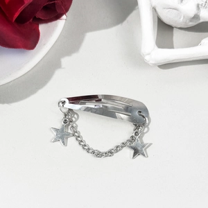 Barrette à cheveux argentée avec pendentifs étoiles et chaîne sur fond gothique