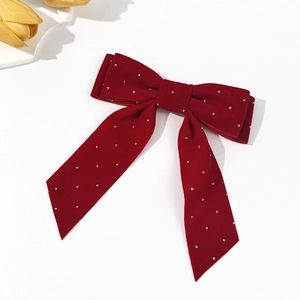 Detail showing wine red velvet bow hair clip with sparkling rhinestones and ribbon