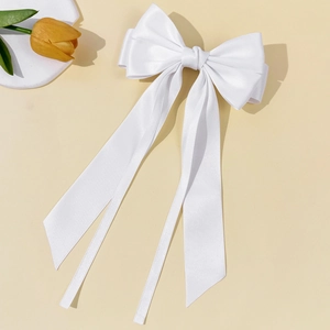 Detailed view of the elegant white satin bow hairclip with long flowing ribbons