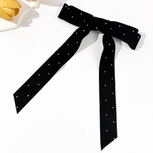Detailed macro view of elegant black velvet bow hair clip with sparkling silver rhinestones