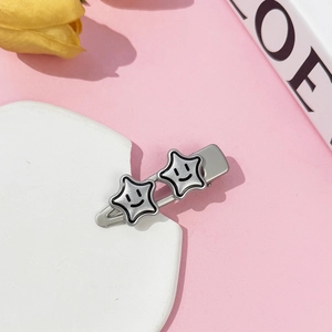 Detailed macro view of silver matte Y2K hair clip with cute star smiley face on white stone