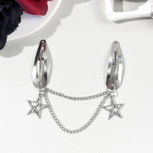 Détail de pinces à cheveux étoiles argentées avec chaînes et pendentifs étoiles