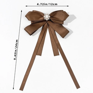 Detail view of coffee brown satin bow brooch with faux pearl and rhinestone centerpiece