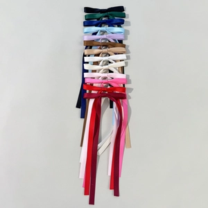 Dettaglio di fermagli per capelli con fiocco in nastro di raso in 13 colori vivaci