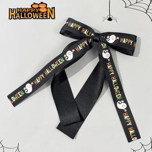 Detail of Halloween hair bow featuring ghost patterns and Happy Halloween lettering