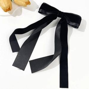 Détail d'un élégant nœud en velours et satin noir avec de longs rubans fluides décoratifs