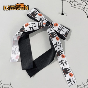 Detail of Halloween hair clip with pumpkin, cat, and castle patterns on ribbon bow