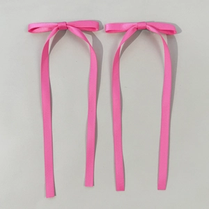 Dettaglio di fiocchi per capelli in raso rosa con nastri lunghi per stile da balletto