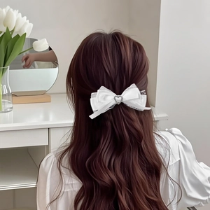 Pinza para el pelo con lazo de satén blanco y strass de corazón en pelo largo ondulado