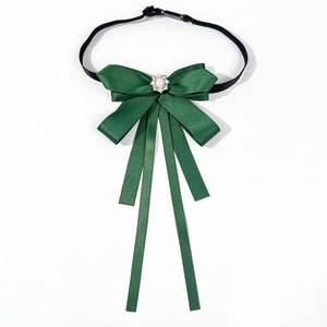 Detail of dark green satin bow tie featuring center pearl and rhinestone accents
