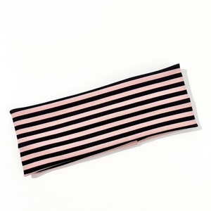 Detailed close-up of pink and black striped elastic sports headband with knit texture