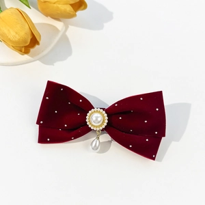Détail de la pince à cheveux en velours avec strass et élégant pendentif en perle