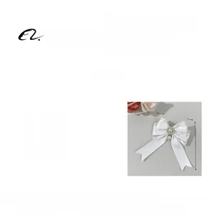Close-up of white lace bow hair clip with central pearl and rhinestone, weighing 12.1g