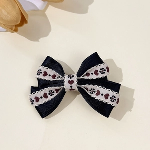 Détail de la pince à cheveux noeud bleu marine avec broderie florale et dentelle blanche