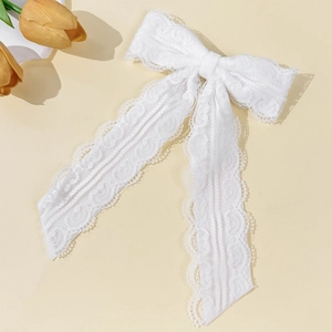 Dettaglio ravvicinato del fiocco in pizzo bianco con motivi floreali e nastri eleganti