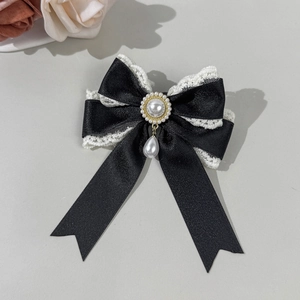 Detailed view of lace bow hair clip with vintage pearls and elegant droplet pendant