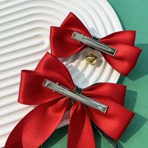 Festive red satin bow hair clips with gold bells and green ribbon for Christmas