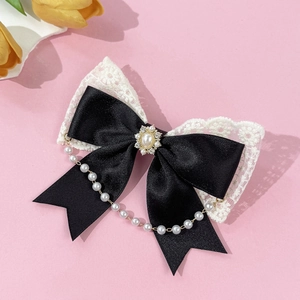 Detail of vintage lace bow hair clip with black ribbon, pearls and rhinestones